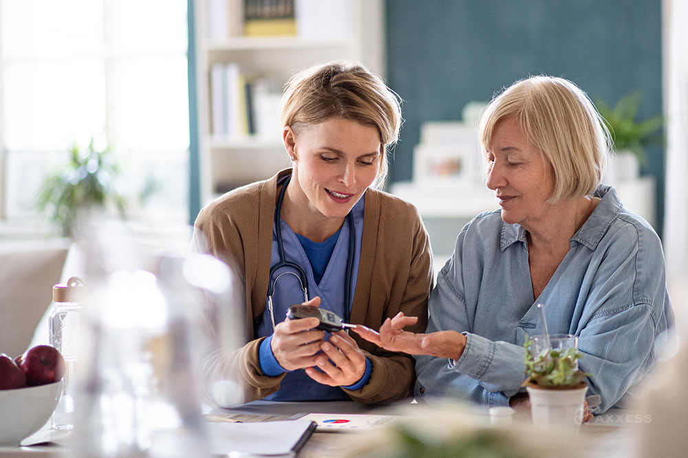 A female clinician takes the blood sugar of an older female patient