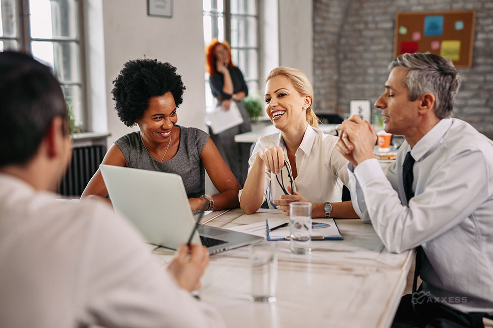 Several business professionals sit at a table having a pleasant conversation